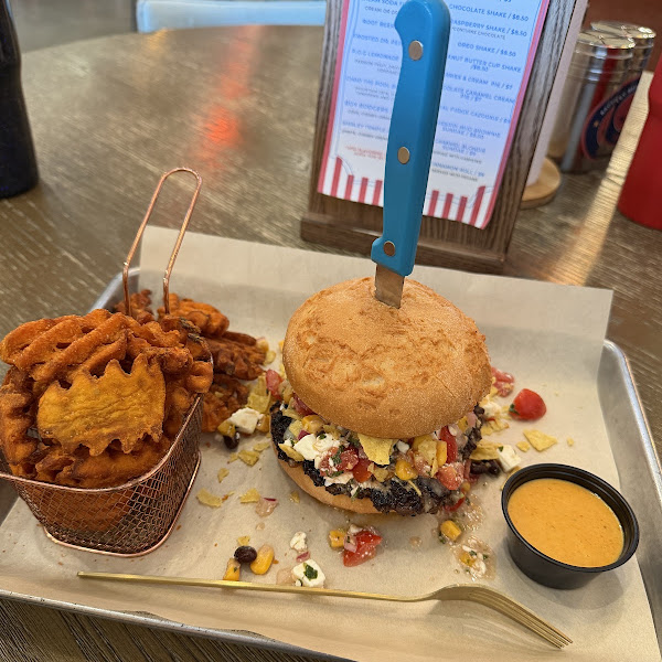Burger on a gluten-free bun with sweet potato waffle fries and dipping sauce